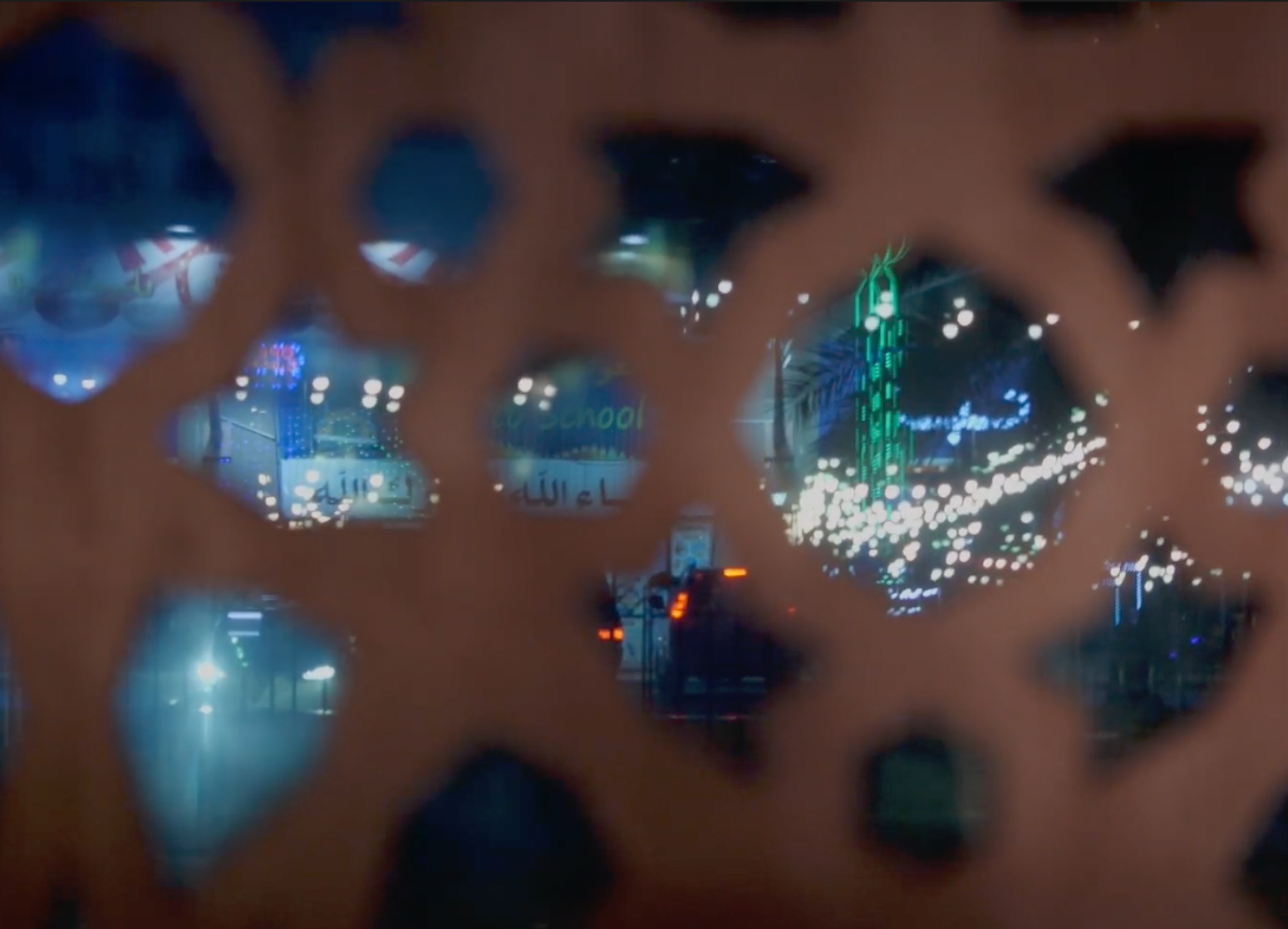 City lights seen through a carved screen at night, from thoughts in transit
